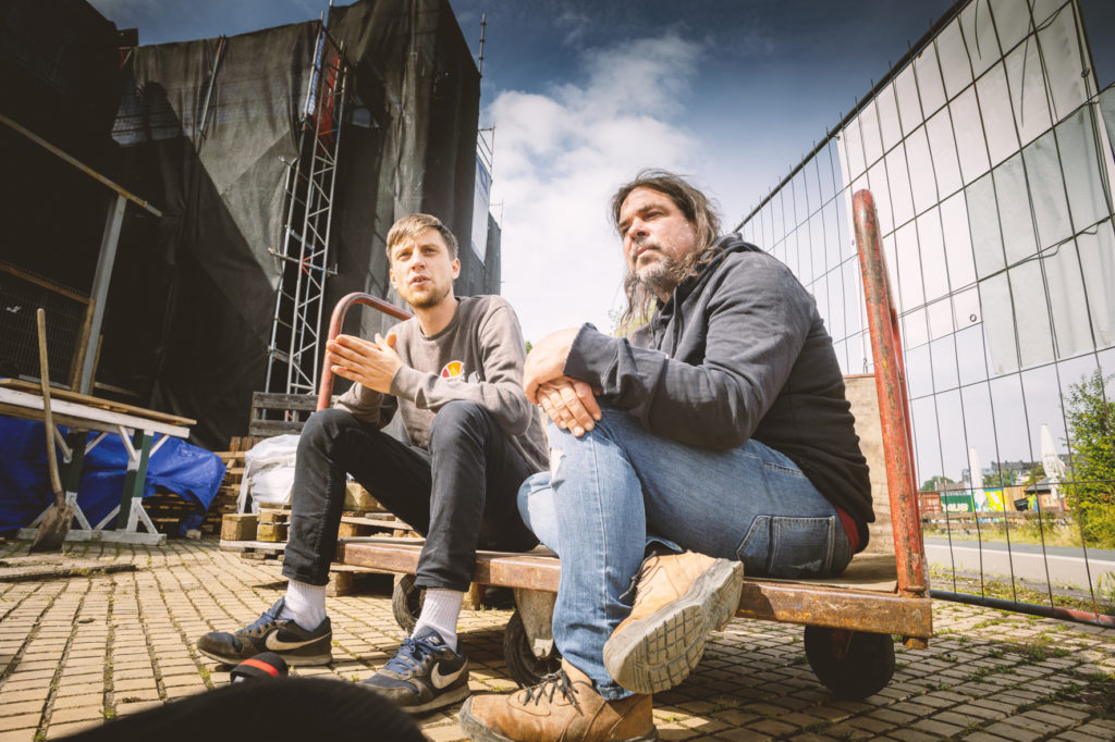 Alex und Niklas auf einem Bauwagen sitzend