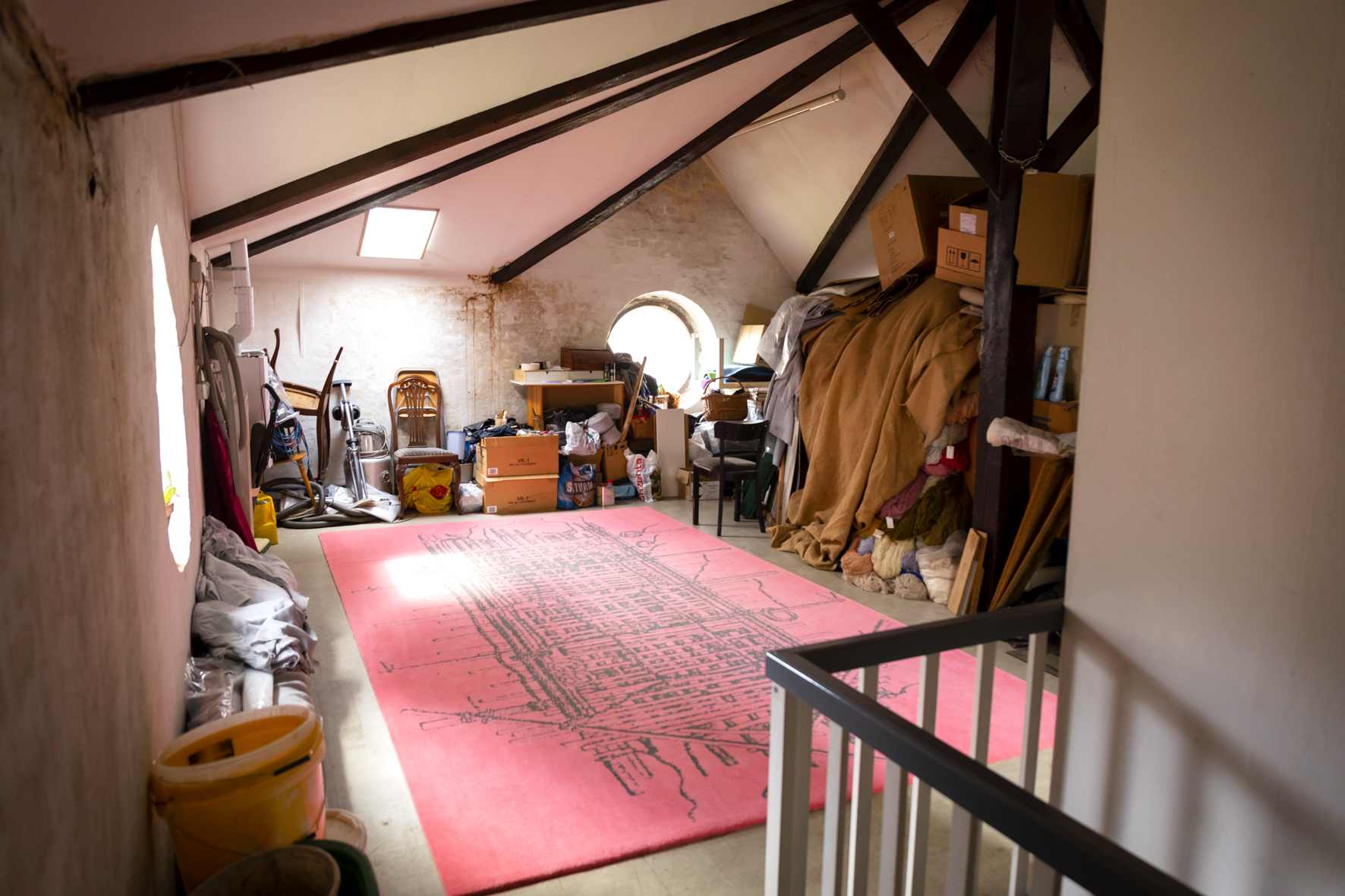 Der letzte Teppich von Wolrad Specht liegt im ersten Obergeschoss. Runtherum liegt sehr viel Kram.